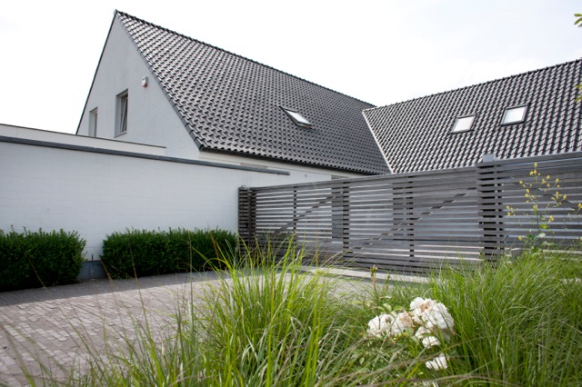 Moderne witte villa met houten hek